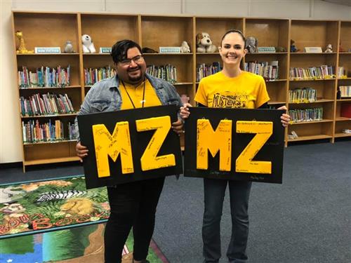 staff members holding colorful MZ signs